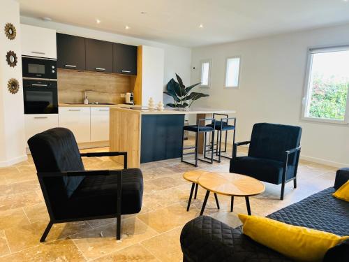 un salon avec un canapé et des chaises et une cuisine dans l'établissement Feel@home Nemausus «Le 31», à Marguerittes