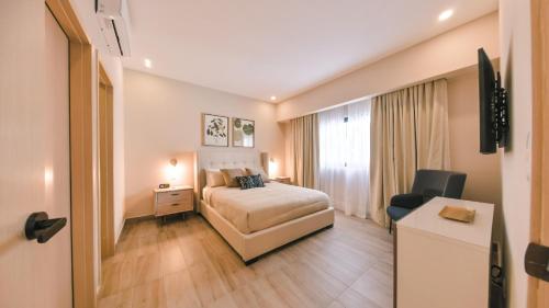 a hotel room with a bed and a desk at Fully Serviced Apartment at Regatta Living II - 304 in Santo Domingo