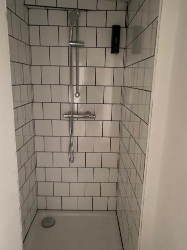 a bathroom with a shower with white tiles at Studio Manhattan WIFI Plein de charme in Gien