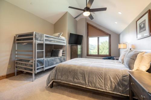a bedroom with a bunk bed and a ceiling fan at Impeccable Lakeside Penthouse in Avon