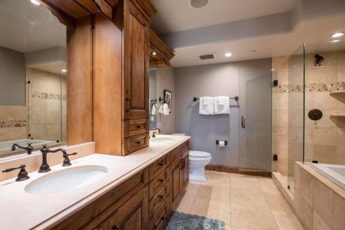a bathroom with a sink and a toilet and a shower at Impeccable Lakeside Penthouse in Avon