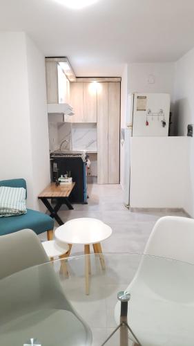 a living room with a table and a refrigerator at Milca Celeste Nueva Córdoba in Córdoba