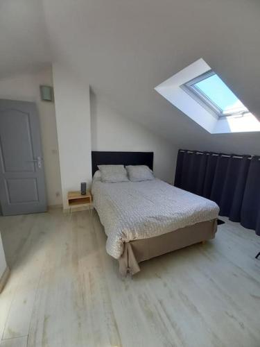 une chambre avec un lit et une lucarne dans l'établissement gîte paisible en pleine nature, à Lolme