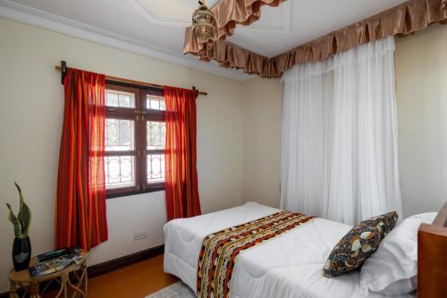 a bedroom with two beds and a window at Gorilla Neighbour Guest House in Entebbe