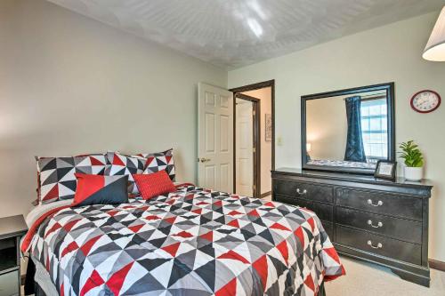 a bedroom with a bed and a dresser and a mirror at Charming Lewisburg Home with Hot Tub and Games! in Lewisburg