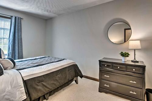 a bedroom with a bed and a mirror and a dresser at Charming Lewisburg Home with Hot Tub and Games! in Lewisburg