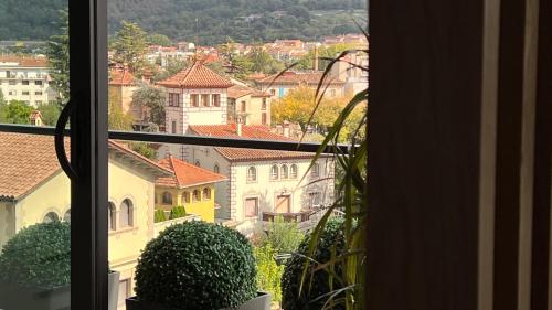 a view of a city from a window at Ático de diseño con terraza en el centro de Olot in Olot