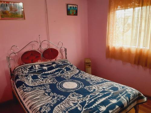 a bedroom with a bed with a blue and white comforter at Hospedaje Chimborazo in Chimborazo