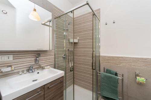 ein Bad mit einem Waschbecken und einer Glasdusche in der Unterkunft [La casa di Rosa] A jewel of elegance at the Vomero in Neapel