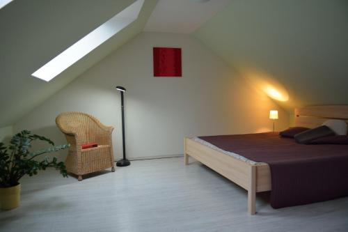 a bedroom with a bed and a chair in a attic at Schleusenwärter Hus in Stralsund