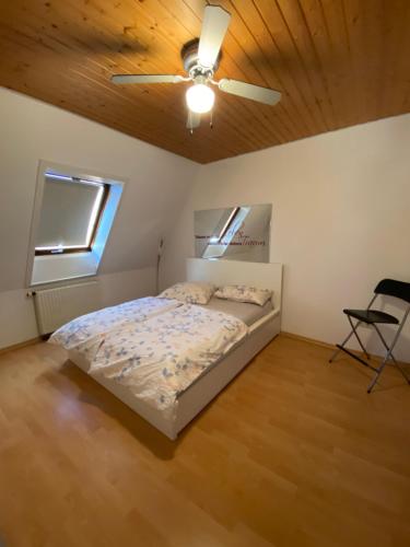 Schlafzimmer mit einem Bett und einem Deckenventilator in der Unterkunft See You Apartment in Germersheim