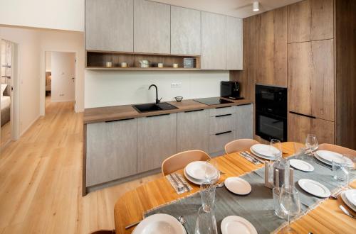 a dining room with a table and a kitchen at Apartmán Hillside Panorama in Dolný Kubín