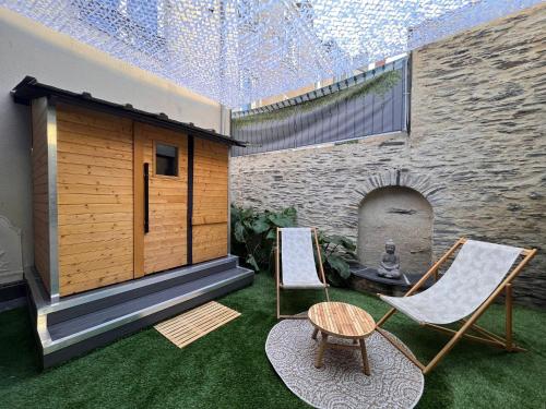 eine Terrasse mit 2 Stühlen und einem Kamin in der Unterkunft Suite Bali Les Petits Plaisirs in Angers