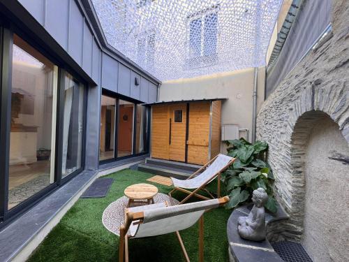 an indoor patio with chairs and a table on a building at Suite Bali Les Petits Plaisirs in Angers