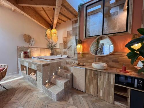 uma cozinha com um balcão de pedra e um espelho em Suite Bali Les Petits Plaisirs em Angers
