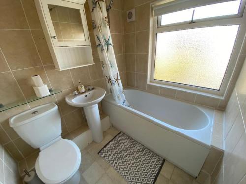 a bathroom with a toilet and a tub and a sink at Poplar House in Cleethorpes