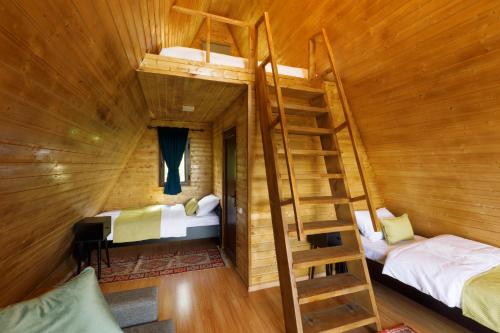 a room with two beds and a staircase in a cabin at Panorama Dashbashi - Hotel in Dashbashi