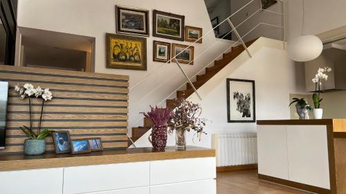 una sala de estar con una escalera con cuadros en la pared en Ático de diseño con terraza en el centro de Olot, en Olot
