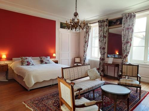 1 dormitorio con cama y pared roja en Maison Zola en Saint-Amand-Montrond