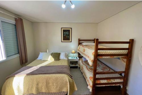 um quarto com 2 beliches e uma escada em Suítes Bela Joao e Maria em Campos de Jordão