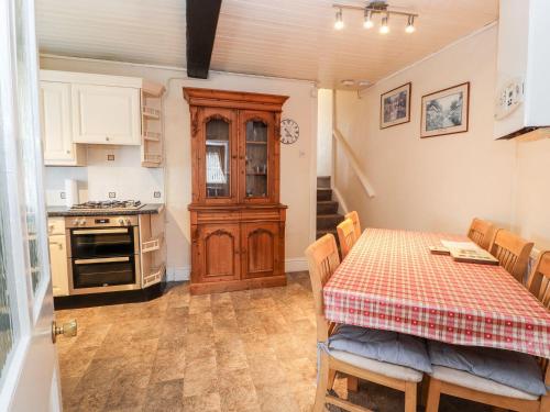 a kitchen with a table and a kitchen with a stove at Scotch Hall Cottage in Llangollen