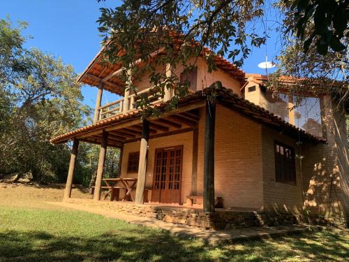 a house with a balcony on top of it at Chico Bertolino / Reserva Alto da Colina in Conceição da Ibitipoca