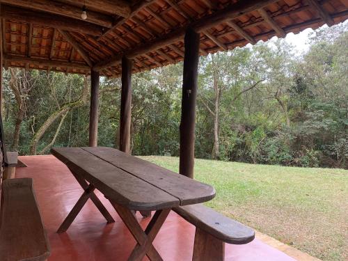 a wooden picnic table sitting under a gazebo at Chico Bertolino / Reserva Alto da Colina in Conceição da Ibitipoca