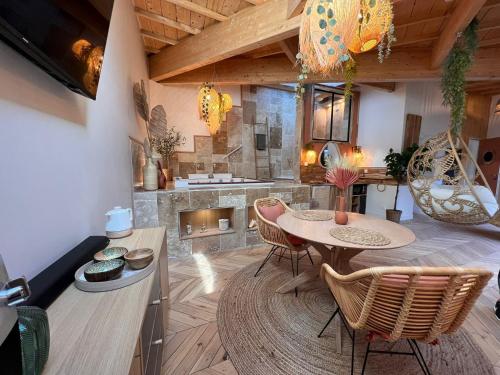 een keuken met een tafel en stoelen en een open haard bij Suite Bali Les Petits Plaisirs in Angers