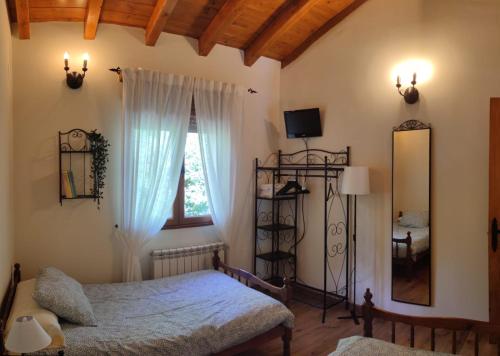 a bedroom with a bed and a window and a mirror at Casa Rural Refugio del Cueto*** in Villamanín
