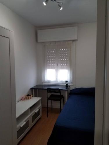 1 dormitorio con cama, escritorio y ventana en Hostal El Caracol, en Valdemoro