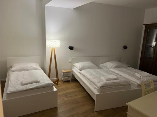 sypialnia z 2 łóżkami i lampką w obiekcie Shone apartment old town w Bratysławie