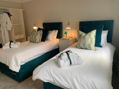 a bedroom with two beds with blue and white pillows at Hideaway Holiday Apartment in Salisbury