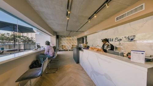 a woman sitting at a counter in a restaurant at Chic Fully Serviced Apartment at Regatta Living II - 705 in Los Prados