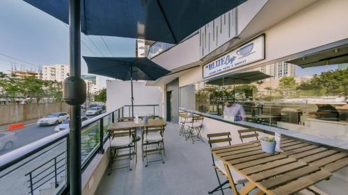 an outdoor patio with tables and chairs and umbrellas at Chic Fully Serviced Apartment at Regatta Living II - 705 in Los Prados