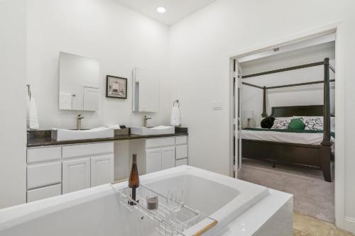 baño blanco con bañera grande y cama en Lavish Downtown Home with Stunning Rooftop Deck Views, en Houston