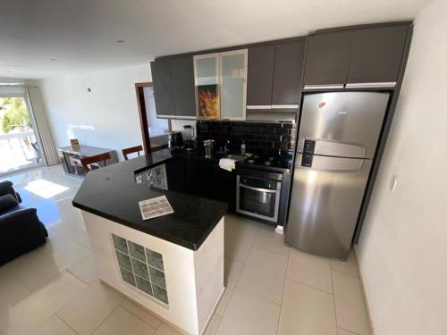 a kitchen with a stainless steel refrigerator and a stove at Canoa Suites & Apartments in Canoa Quebrada
