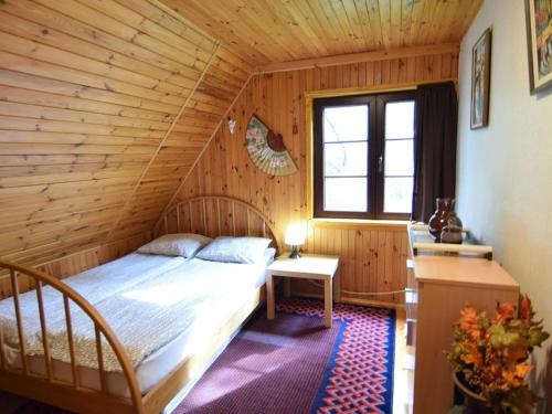 una camera da letto con letto in una camera in legno di holiday home, Zuromino a Żuromino