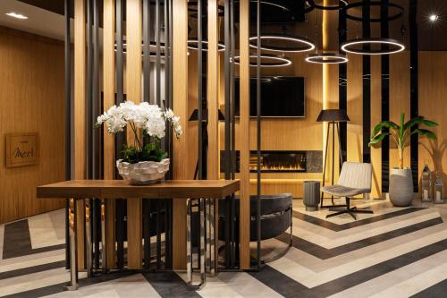 -- ESTE PARK HOTEL -- part of Urban Chic Luxury Design Hotels - Parking & Compliments - next to Shopping & Dining Mall Plovdiv في بلوفديف: لوبي مع إناء ورد على طاولة