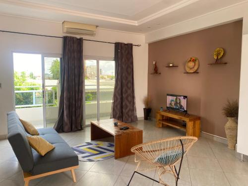 a living room with a couch and a tv at L'Oasis Guesthouse in Cotonou