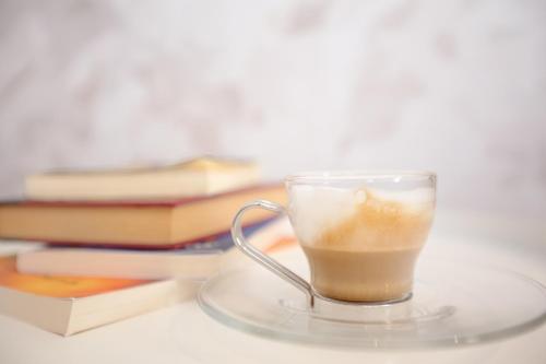 a glass cup of coffee sitting on a table with books at LA DAMA in San Vito lo Capo