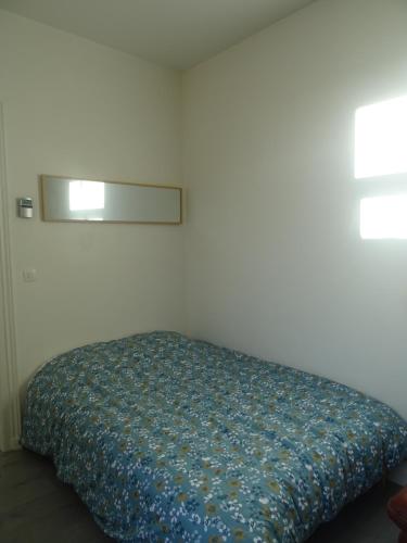 - une chambre avec un lit et une couette bleue dans l'établissement Charmant studio en centre-ville, à Boulogne-sur-Mer