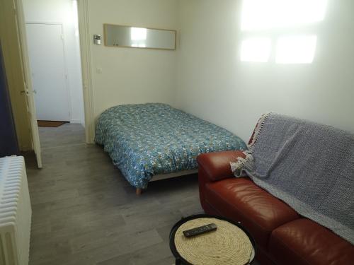 - un salon avec un canapé et un lit dans l'établissement Charmant studio en centre-ville, à Boulogne-sur-Mer