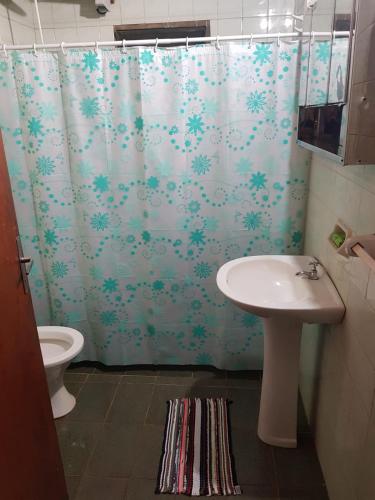 a bathroom with a shower curtain and a sink at Casa Doña Isabel in Puerto Iguazú