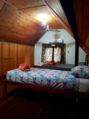 a bedroom with two beds and a ceiling at Casa Doña Isabel in Puerto Iguazú