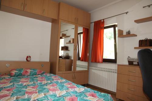 Schlafzimmer mit einem Bett, einer Kommode und einem Spiegel in der Unterkunft HSH Apartments in Sarajevo