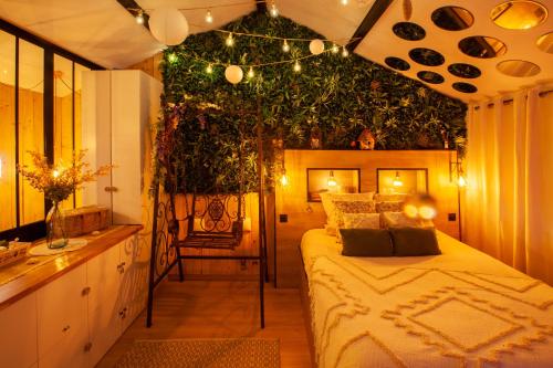 a bedroom with a bed with a plant on the wall at Love Room Romantique Les Petits Plaisirs in Angers