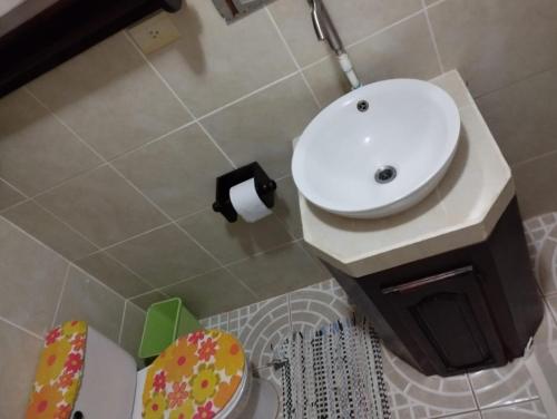 a bathroom with a white sink and a toilet at Casa Sol in Sarapiquí