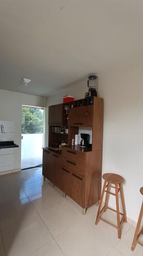 a kitchen with a wooden cabinet and a stool at Dream House in Itacimirim