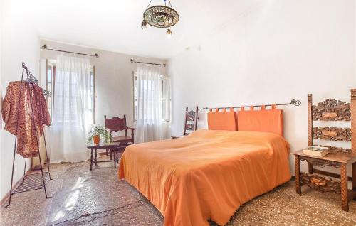 ein Schlafzimmer mit einem Bett mit einer orangefarbenen Tagesdecke in der Unterkunft Beautiful Apartment In Feltre With Kitchen in Feltre