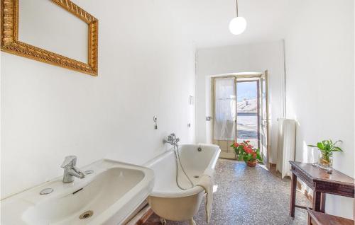 ein weißes Bad mit einer Badewanne und einem Spiegel in der Unterkunft Beautiful Apartment In Feltre With Kitchen in Feltre